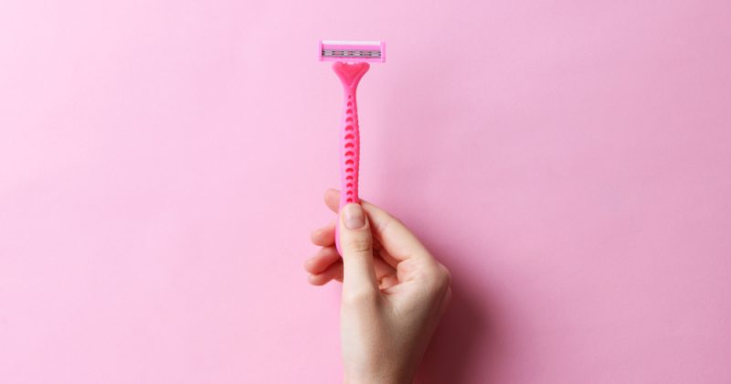 Razor,In,A,Female,Hand,On,A,Colored,Background.,Removal